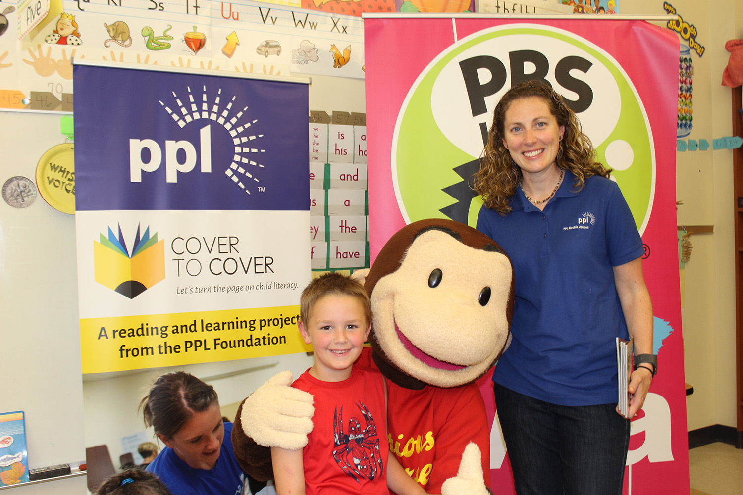PPL Regional Affairs Director Alana Roberts poses with a youngster at Stourbridge Primary Center in Honesdale, Pa. PPL partnered with WVIA to bring the Cover to Cover program to Stourbridge.