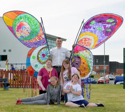 WPD Planner Mark Mears, is pictured with volunteers and members of the Sparkle youth club and craft group from the Serennu Centre, with their butterfly banner. 