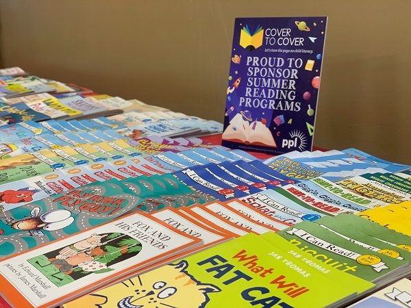 Books on table for children to pick up during Cover to Cover literacy program
